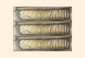 Bulk packaged three trays of chocolate chip Bulk packaged three trays of chocolate chip cookies stacked neatly in a cardboard box and wrapped