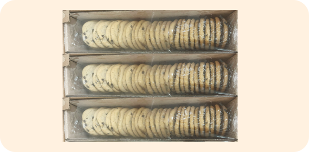 Bulk packaged three trays of chocolate chip cookies stacked neatly in a cardboard box and wrapped