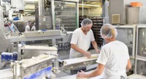 Workers preparing dough on an automated bread production line