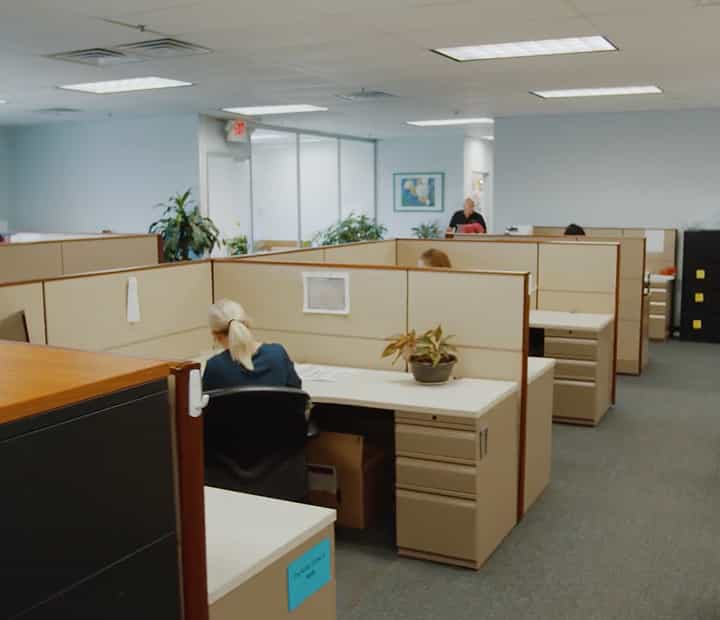 Open-plan office with cubicles and employees working at desks