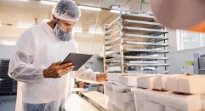 Food technician reviewing baked products on a tablet in a test area