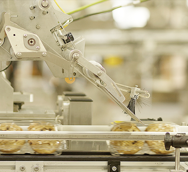 A robotic arm used for labeling and full traceability of the cookies moving along a conveyor belt